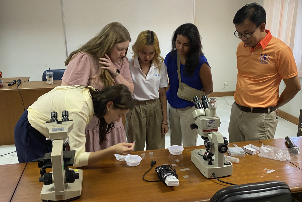 students at a microscope